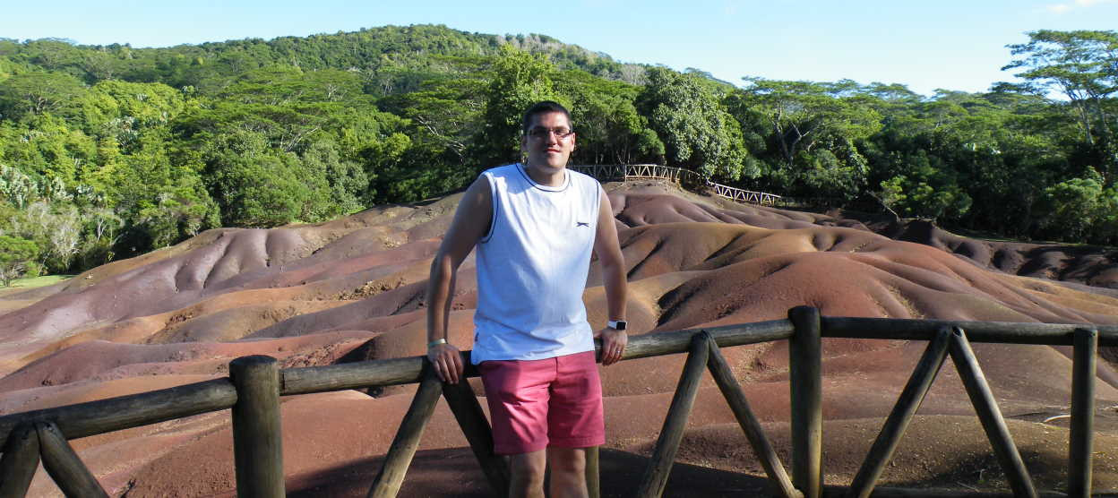 Photo of Andy Heathershaw in front of some volcanic rock in Mauritius.